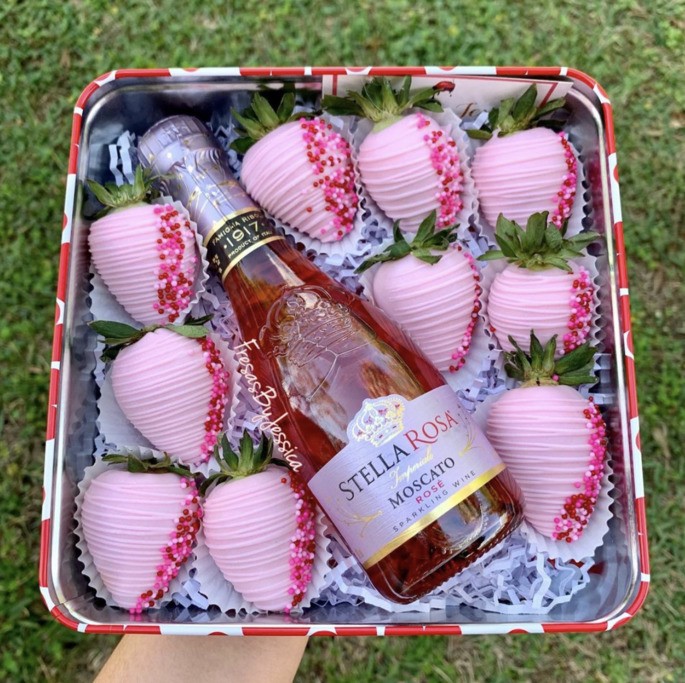 Cajas con caramelos rosas y champán rosa.