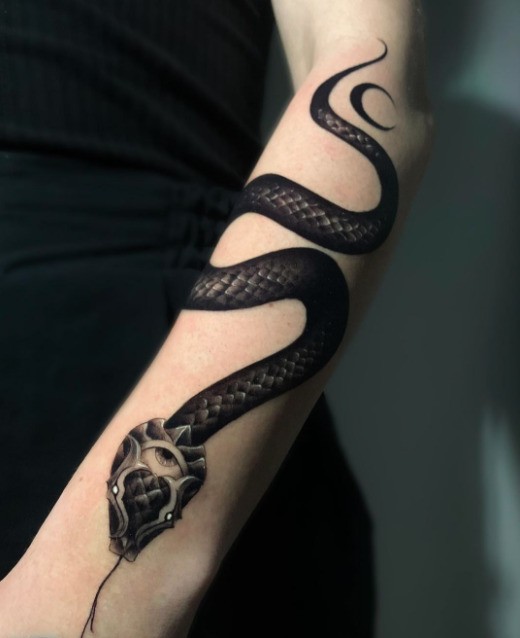 Tatuaje de serpiente en el brazo.
