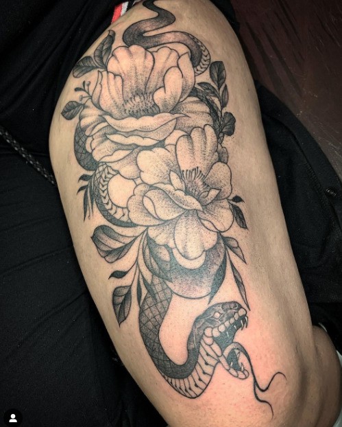 Tatuaje de serpiente femenina en la pierna.