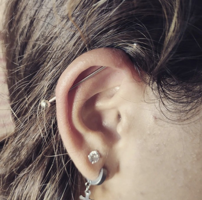 Oreja con perforación cruzada