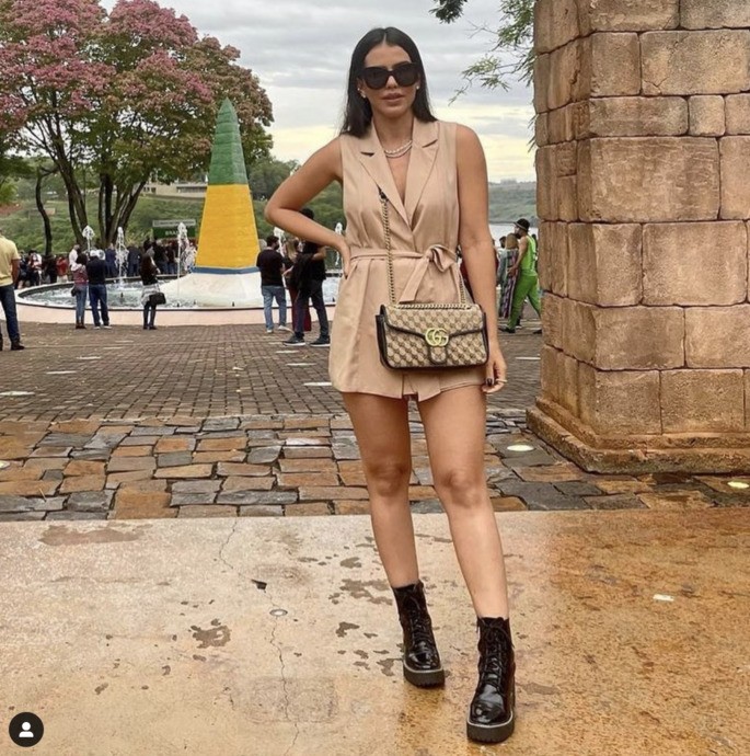 La mujer posa para una foto con un mono negro y botas.